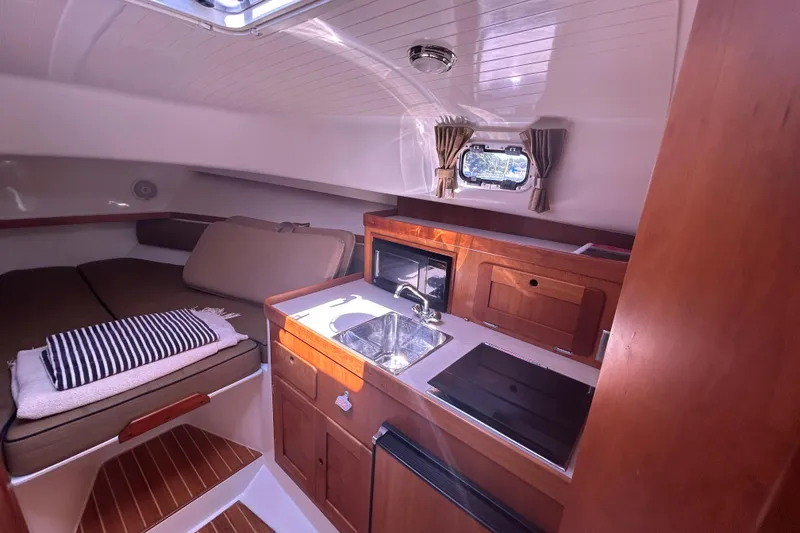 Slide: The Image of 2005 Hunt Yachts Surfhunter 33 cockpit with steering wheel, controls, and seating, docked by the water. - 10