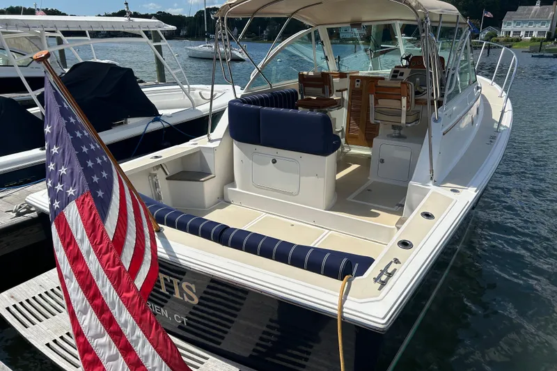 Slide: The Image of 2005 Hunt Yachts Surfhunter 33 docked, featuring spacious deck and American flag. - 2