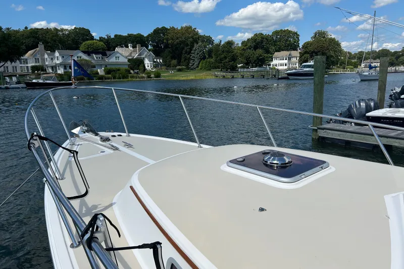 Slide: The Image of 2005 Hunt Yachts Surfhunter 33 docked, featuring a spacious deck and American flag. - 5
