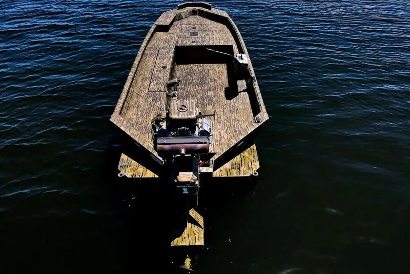 Slide: The Image of 2026 SeaArk 1752 Slayer X Pro boat on calm water, aerial view. - 12