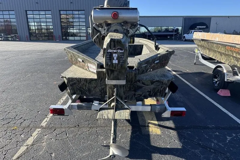 Slide: The Image of 2026 SeaArk 1752 Slayer X Pro boat on trailer, camo design, outdoor dealership. - 15