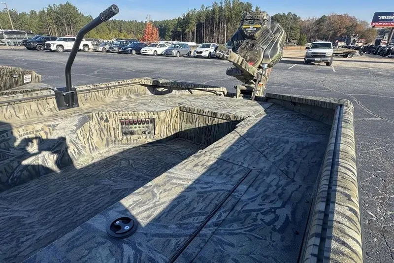 Slide: The Image of 2026 SeaArk 1752 Slayer X Pro boat with camouflage design in a parking lot. - 5
