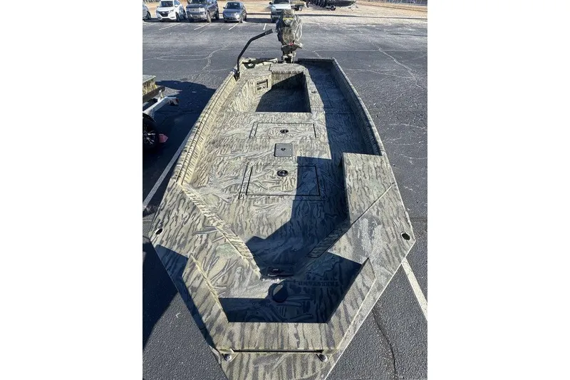 Slide: The Image of 2026 SeaArk 1752 Slayer X Pro boat with camouflage design, parked on asphalt. - 7
