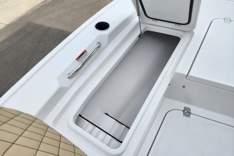 Slide: The Image of 2026 Sportsman Masters 227 Bay Boat storage compartment with open hatch and cushioned seating. - 12