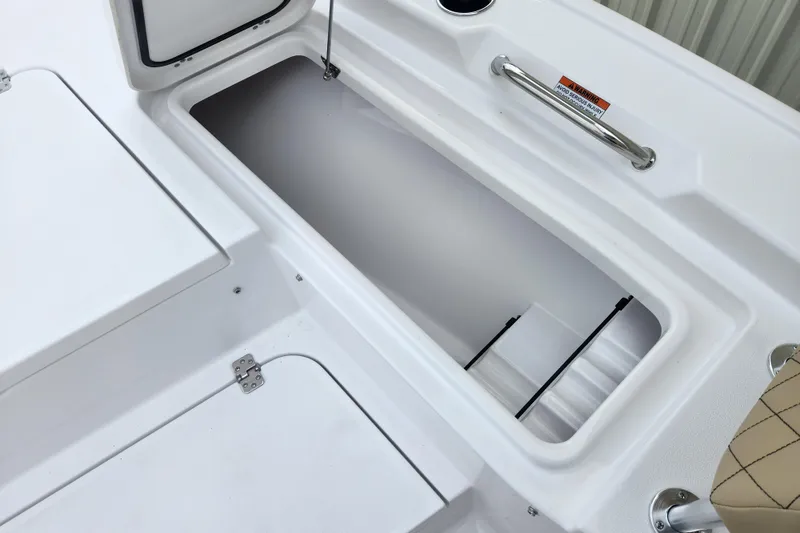 Slide: The Image of 2026 Sportsman Masters 227 Bay Boat storage compartment with open hatch and handle. - 13