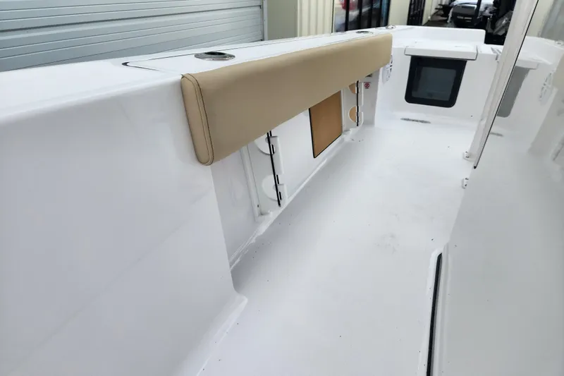 Slide: The Image of 2026 Sportsman Masters 227 Bay Boat interior with beige cushioned seating. - 20