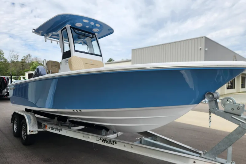 Slide: The Image of 2026 Sportsman Masters 227 Bay Boat on trailer, blue hull, parked outdoors. - 5