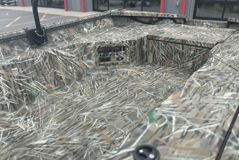 Slide: The Image of 2026 SeaArk 1752 Slayer X boat with camouflage design, docked outside a building. - 15