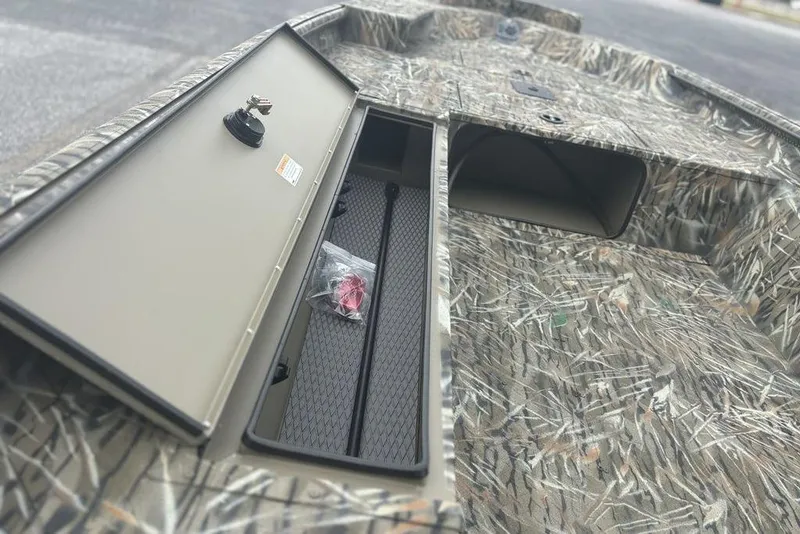 Slide: The Image of 2026 SeaArk 1752 Slayer X boat with open storage compartments and camouflage design. - 19