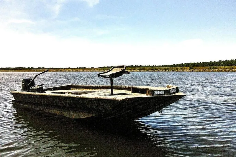 Slide: The Image of 2026 SeaArk 1752 Slayer X boat on calm lake under clear sky. - 28