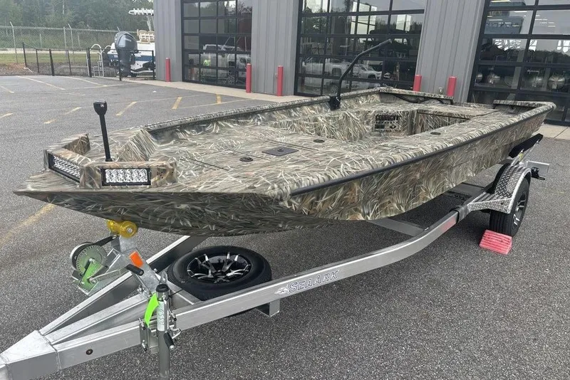 Slide: The Image of 2026 SeaArk 1752 Slayer X boat with Mercury engine, camo design, on a trailer. - 6