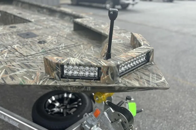 Slide: The Image of 2026 SeaArk 1752 Slayer X boat on trailer, parked outdoors near trucks. - 8