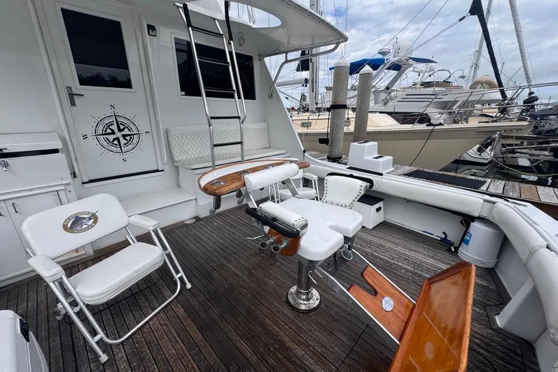 Slide: The Image of 1979 Hatteras 53 Motor Yacht deck with fishing chairs and nautical decor at marina. - 24