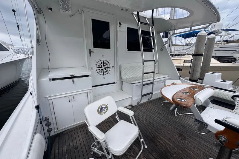 Slide: The Image of 1979 Hatteras 53 Motor Yacht deck with seating, ladder, and nautical decor. - 25