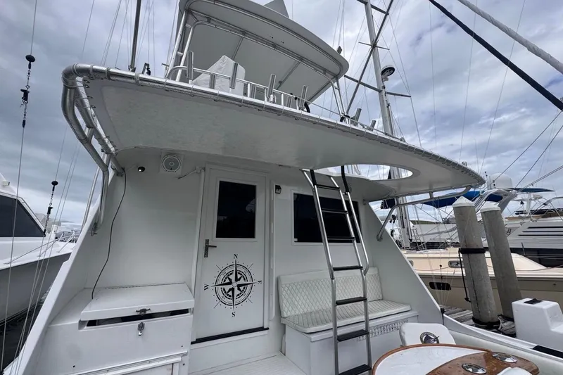 Slide: The Image of 1979 Hatteras 53 Motor Yacht with ladder and seating, docked at marina. - 26