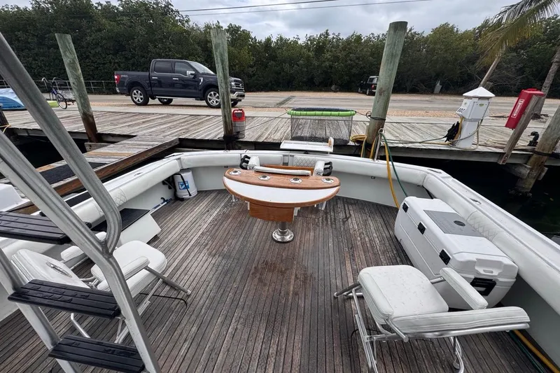 Slide: The Image of 1979 Hatteras 53 Motor Yacht deck with seating, table, and dock view. - 32