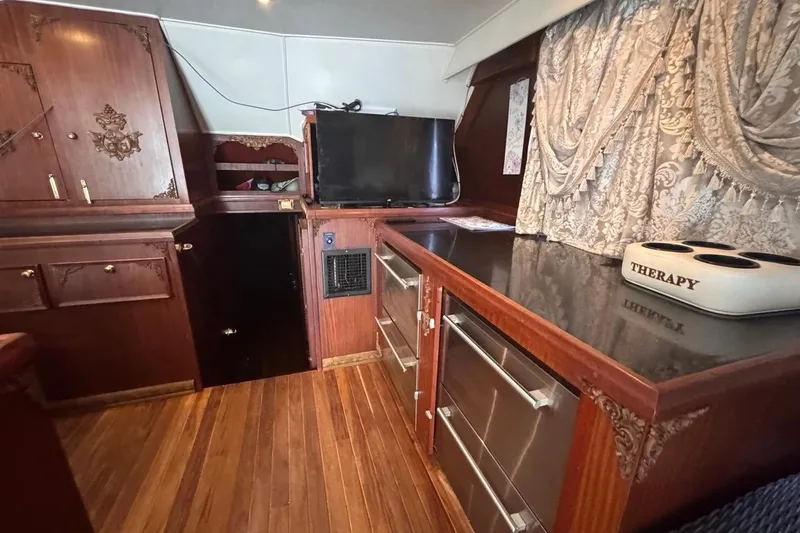 Slide: The Image of Interior of a 1979 Hatteras 53 Motor Yacht with wood cabinetry and elegant drapery. - 36