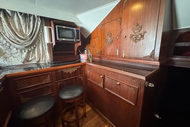 Slide: The Image of Luxurious wooden interior of a 1979 Hatteras 53 Motor Yacht with ornate cabinetry. - 38