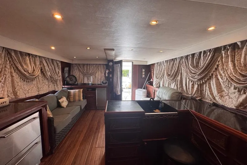 Slide: The Image of Interior of a 1979 Hatteras 53 Motor Yacht with elegant drapes and wooden furnishings. - 50