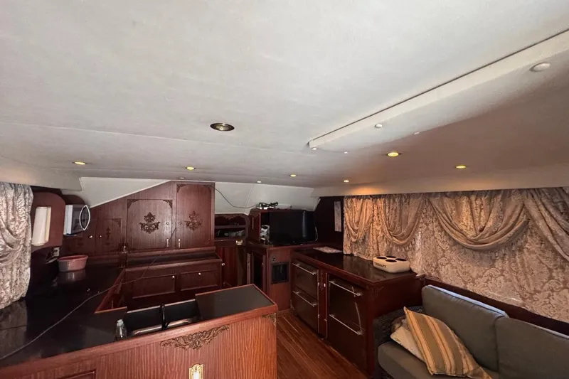 Slide: The Image of Interior of a 1979 Hatteras 53 Motor Yacht with elegant wood finishes and draped curtains. - 51