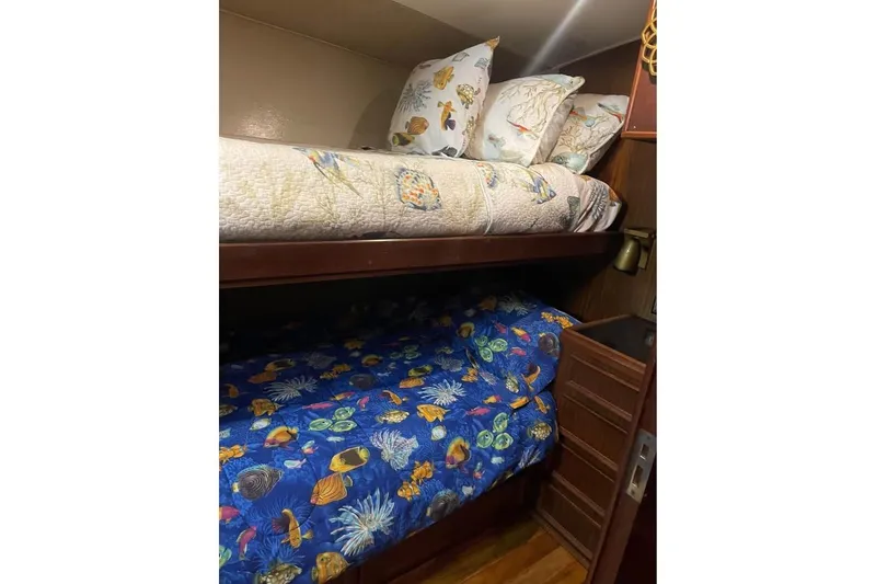 Slide: The Image of Bunk beds with marine-themed bedding in a 1979 Hatteras Sportfish 53' yacht cabin. - 63