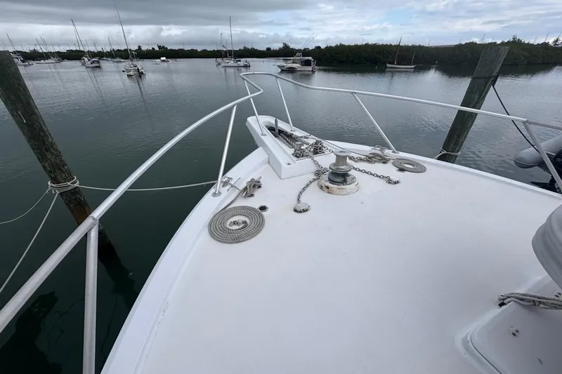 Slide: The Image of 1979 Hatteras 53 Motor Yacht bow with anchor chain, docked in a calm marina. - 71