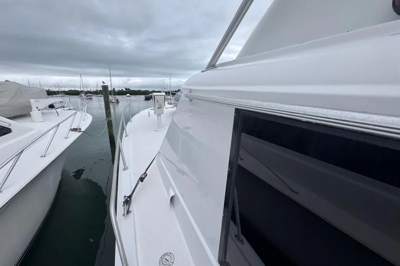 Slide: The Image of 1979 Hatteras 53 Motor Yacht docked in a marina under cloudy skies. - 77