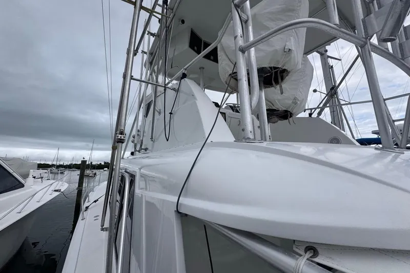 Slide: The Image of 1979 Hatteras 53 Motor Yacht docked under cloudy skies, showcasing sleek design and structure. - 81