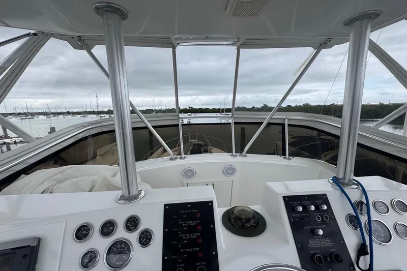 Slide: The Image of 1979 Hatteras 53 Motor Yacht helm with gauges and marina view. - 85