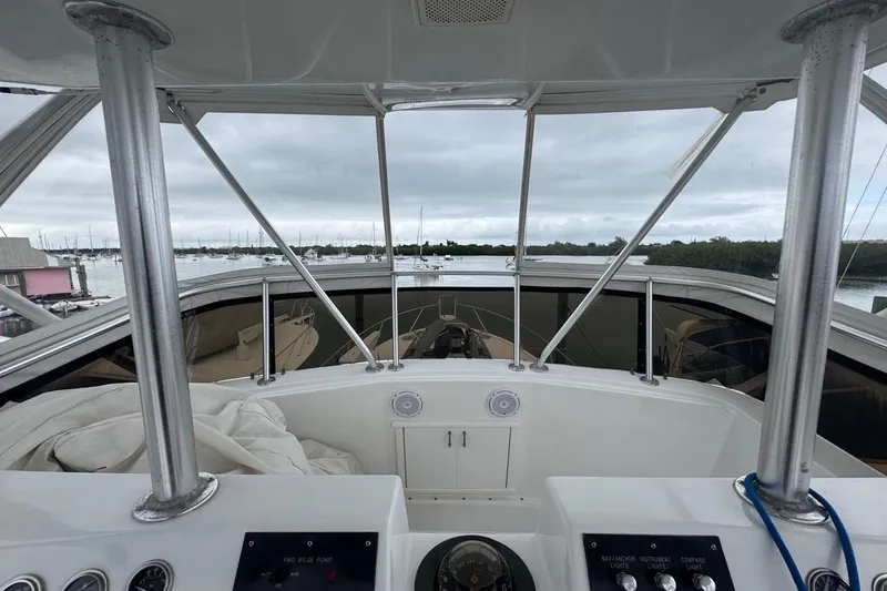 Slide: The Image of 1979 Hatteras 53 Motor Yacht helm view with marina backdrop. - 87