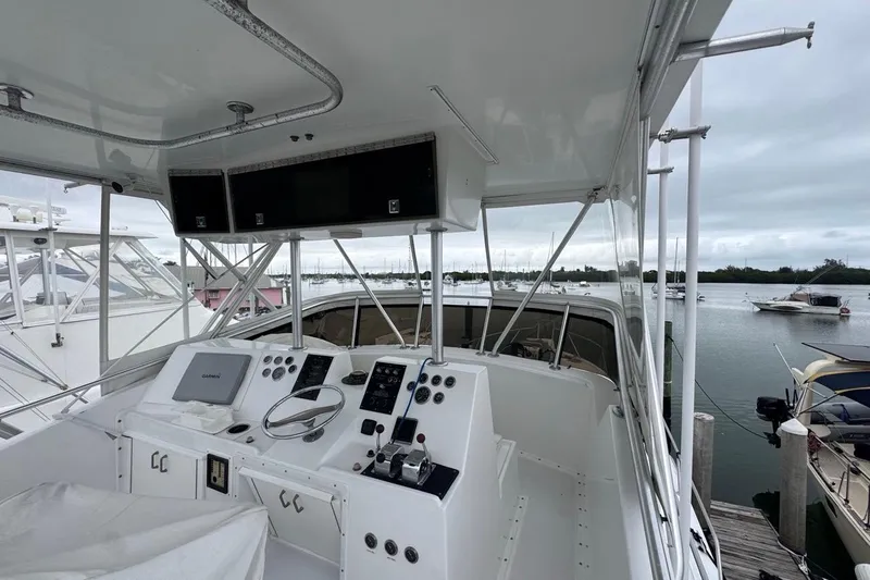 Slide: The Image of 1979 Hatteras 53 Motor Yacht helm with navigation equipment, docked in a marina. - 90