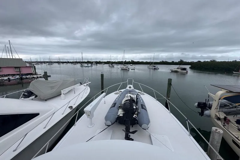 Slide: The Image of 1979 Hatteras 53 Motor Yacht docked in a marina under cloudy skies. - 92