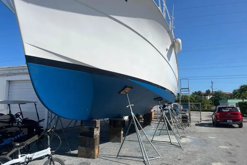 Slide: The Image of 1979 Hatteras Sportfish 53' yacht on dry dock, blue hull, sunny day. - 95