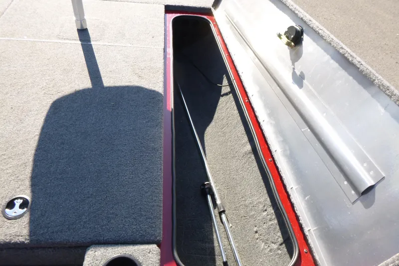 Slide: The Image of 2020 Tracker Pro Team 190 TX boat storage compartment with carpeted interior and rod holder. - 14