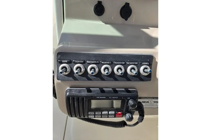 Slide: The Image of Control panel of a 2014 Boston Whaler 270 Vantage boat with switches and VHF radio. - 17