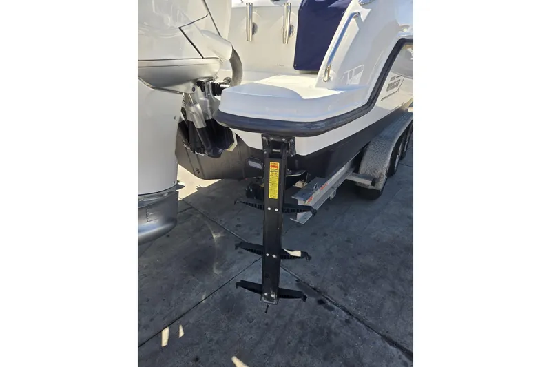 Slide: The Image of 2014 Boston Whaler 270 Vantage boat on trailer, rear view with motor and support stand. - 19