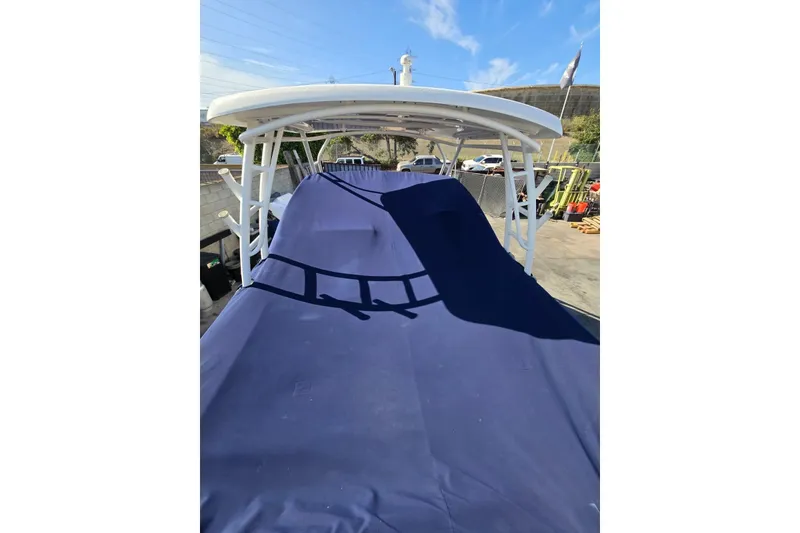 Slide: The Image of 2014 Boston Whaler 270 Vantage covered with a blue tarp, docked outdoors. - 24