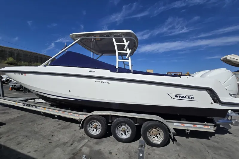 Slide: The Image of 2014 Boston Whaler 270 Vantage boat on trailer under clear blue sky. - 25