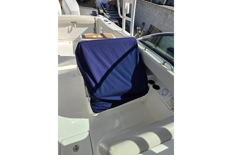 Slide: The Image of 2014 Boston Whaler 270 Vantage boat interior with blue seat cover and cup holders. - 26