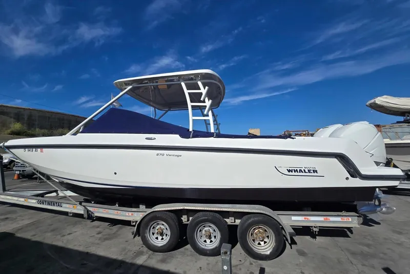 Slide: The Image of 2014 Boston Whaler 270 Vantage boat on trailer under clear blue sky. - 27