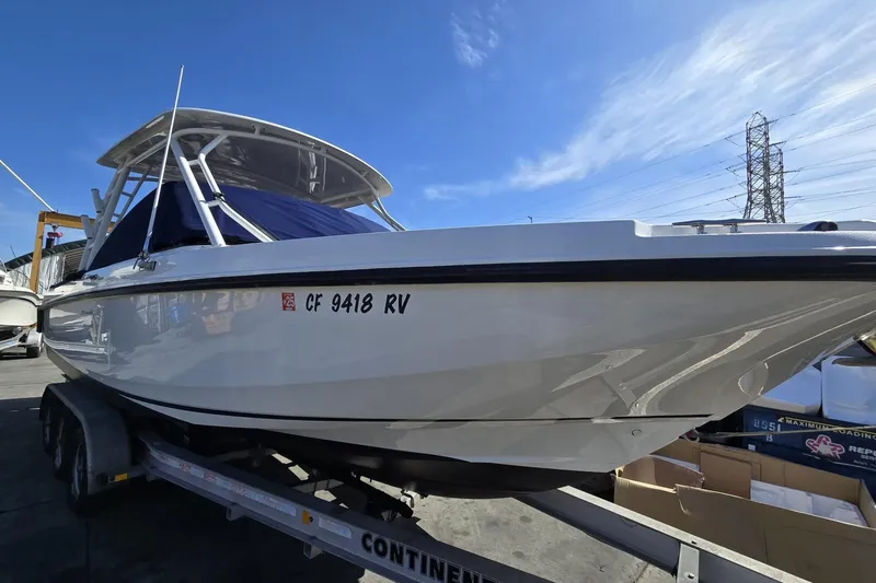 Slide: The Image of 2014 Boston Whaler 270 Vantage boat on trailer under clear blue sky. - 28