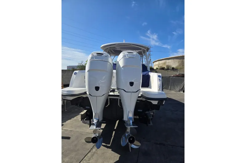 Slide: The Image of 2014 Boston Whaler 270 Vantage with dual outboard engines, docked under clear blue sky. - 30