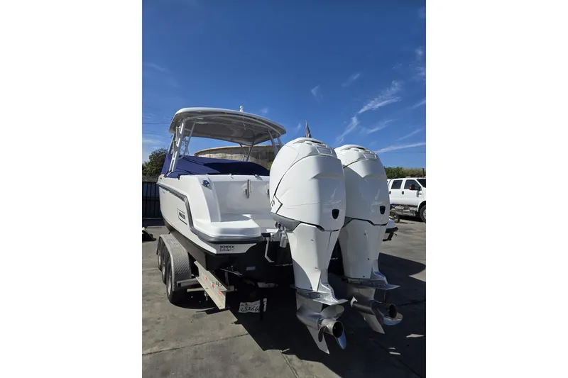 Slide: The Image of 2014 Boston Whaler 270 Vantage boat with dual outboard engines on a trailer. - 31