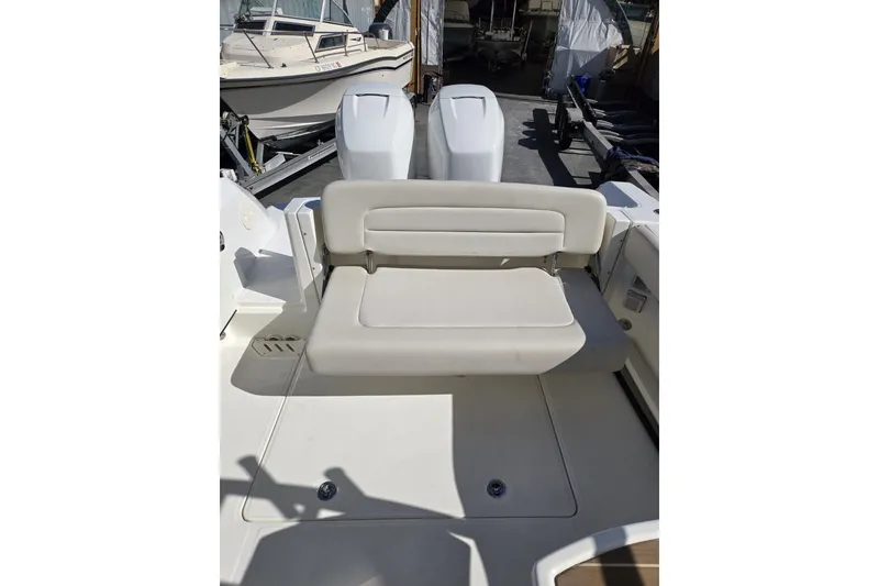 Slide: The Image of 2014 Boston Whaler 270 Vantage boat interior with foldable seating and dual engines. - 33