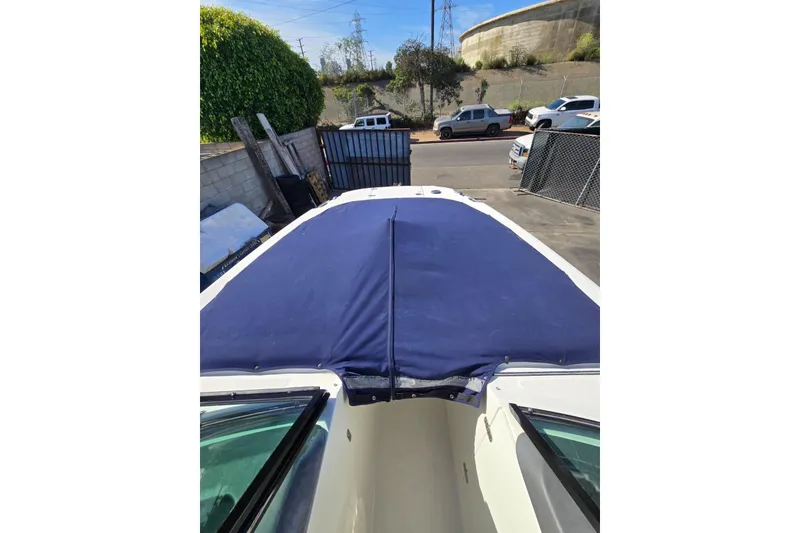 Slide: The Image of 2014 Boston Whaler 270 Vantage boat with blue cover in a parking area. - 34