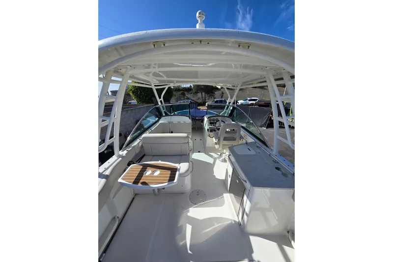Slide: The Image of 2014 Boston Whaler 270 Vantage boat interior with seating and helm under blue sky. - 36