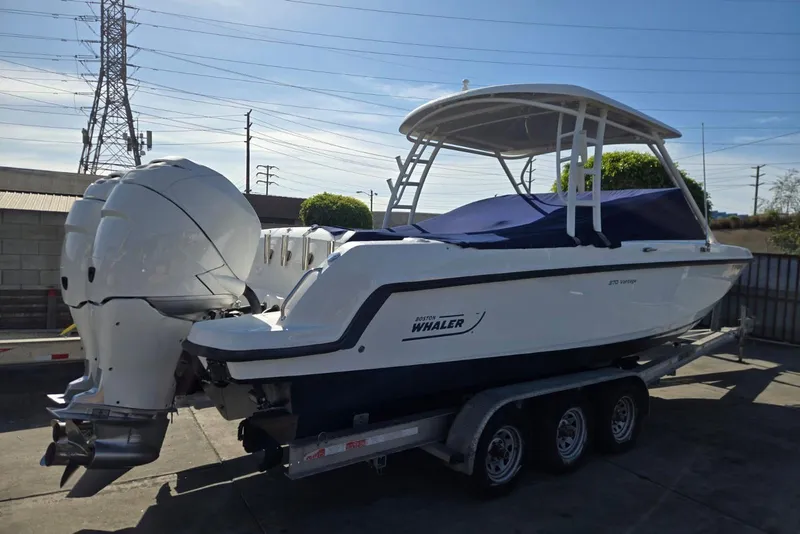 Slide: The Image of 2014 Boston Whaler 270 Vantage boat on trailer, featuring dual outboard engines. - 37