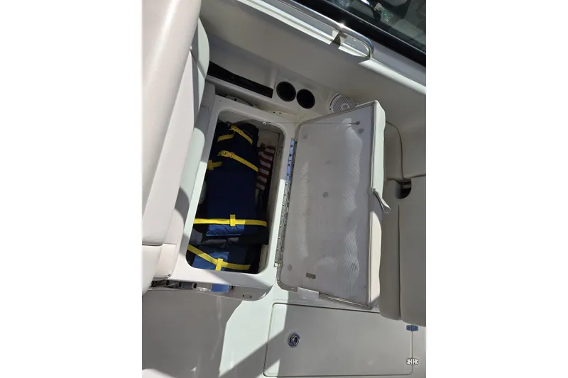 Slide: The Image of 2014 Boston Whaler 270 Vantage storage compartment with life jackets and cup holders. - 47
