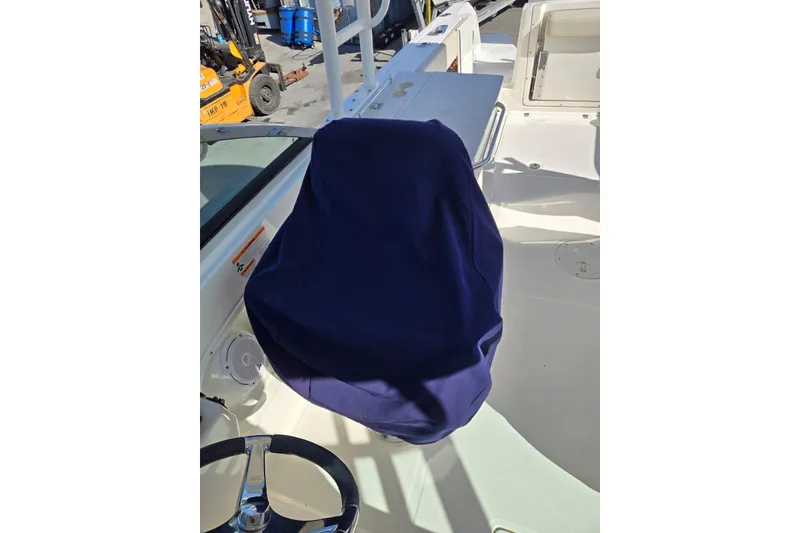 Slide: The Image of 2014 Boston Whaler 270 Vantage boat interior with covered seat and steering wheel. - 49