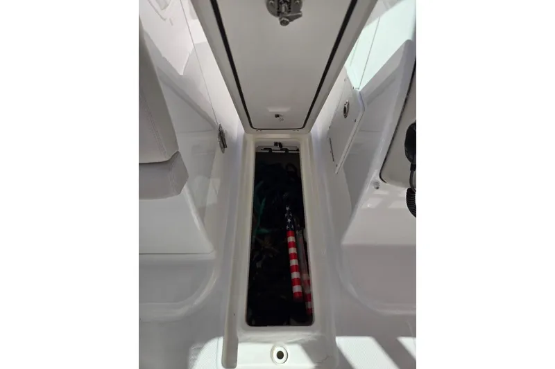 Slide: The Image of 2014 Boston Whaler 270 Vantage storage compartment with American flag inside. - 54